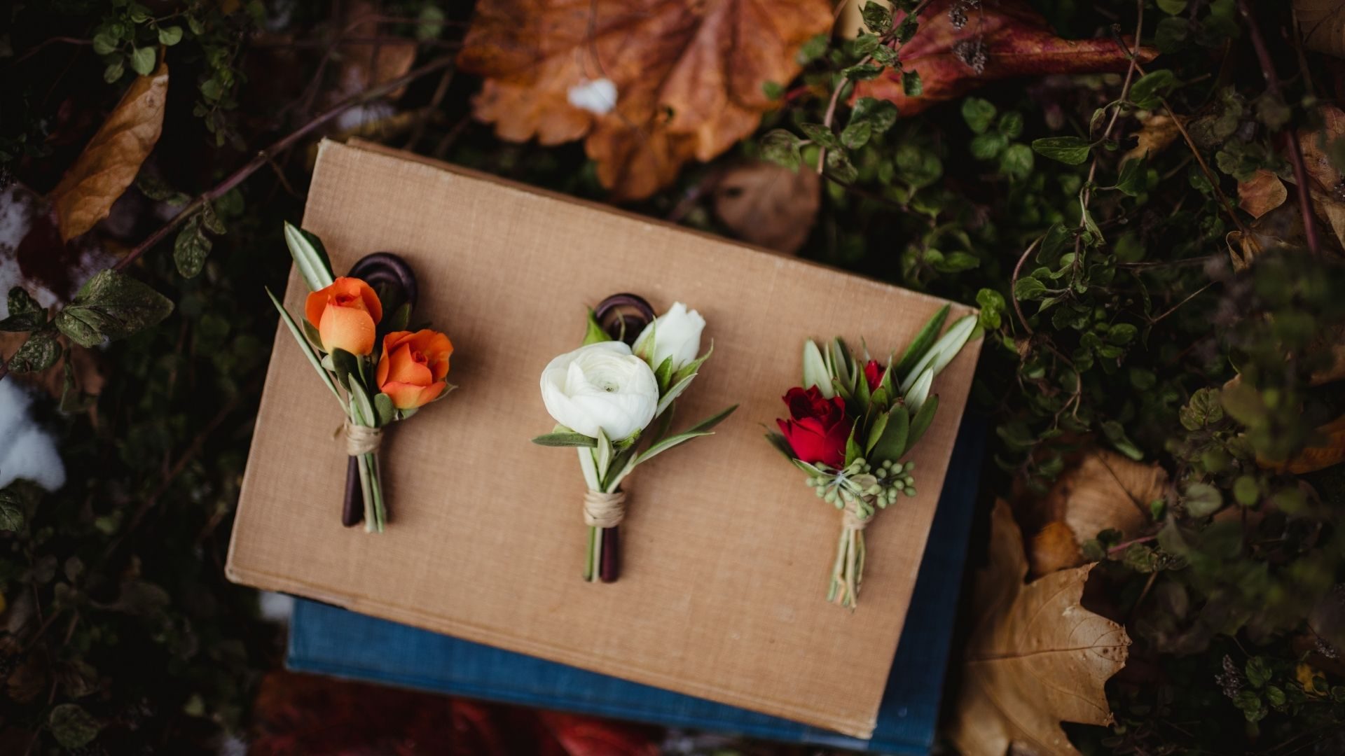 Tres prendidos de flores frescas sobre un libro